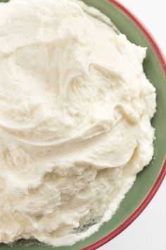 a green plate topped with whipped cream on top of a table