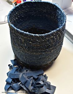 a blue bowl sitting on top of a white table next to some scissors and thread