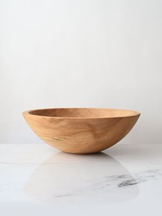 a wooden bowl sitting on top of a white counter