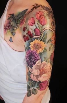 a woman's arm with flowers and birds on it