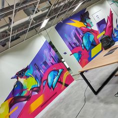 an office with colorful paintings on the walls