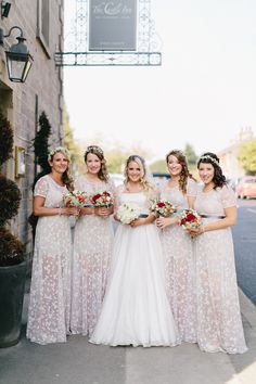 a group of women standing next to each other in front of a tall brick building