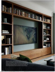 a living room filled with furniture and bookshelves next to a flat screen tv