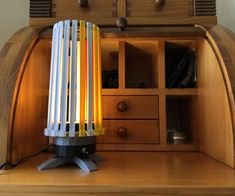 a lamp is sitting on top of a wooden shelf in front of a cabinet with drawers