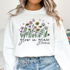 a woman wearing a white crop top that says grown in grace with flowers and butterflies