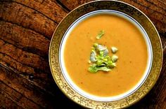 a bowl filled with soup on top of a wooden table