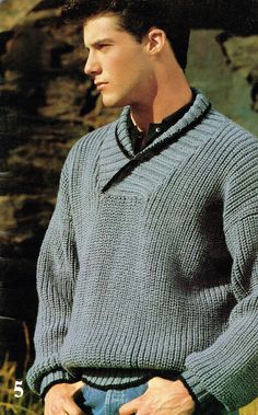 a young man wearing a sweater and jeans