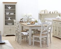 a dining room table with chairs and plates on it