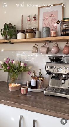 a coffee maker sitting on top of a kitchen counter next to flowers and candles in vases