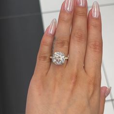 a woman's hand with a ring on it and a diamond in the middle