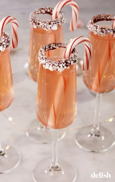 three glasses with candy canes in them sitting on a table