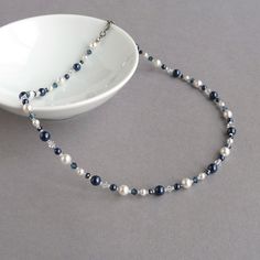 This navy and white necklace has been created using glass pearls, sparkling crystals and glass beads. The crystals really sparkle when they catch the light and the pearls have an opulent lustre. This midnight blue necklace measures 18.25 inches in length and is finished with a gunmetal-plated lobster clasp. I have added a 2 inch extension chain to allow you to adjust your necklace to fit.  Your jewellery will be carefully gift wrapped in the pretty, black box pictured and securely packaged to ensure its safe arrival. --------------------- Matching items available --------------------- 6mm navy pearl studs: https://www.etsy.com/uk/listing/1247193409 Navy pearl drop earrings: https://www.etsy.com/uk/listing/710637392 6mm white pearl studs: https://www.etsy.com/uk/listing/153464177 ---------- Crystals Beads Necklace, Blue Single Strand Beaded Necklace For Wedding, Blue Single Strand Wedding Necklace, Blue Beaded Pearl Necklace For Wedding, Chunky Stone Necklace, Necklaces Wedding, Chunky Pearl Necklace, White Pearl Jewelry, Silver Bar Earrings