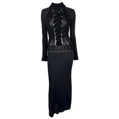 Presenting a stunning black knit Thierry Mugler long-sleeve gown, designed by Manfred Mugler. From the Mid-1990s, this knit bodycon dress features a mock neck and stands out with a sheer torso with a scrolling velvet devoré pattern creating a faux cable knit effect. The sheer torso adds the perfect seductive touch to this form-fitting stretch maxi dress. Chic and sexy, this vintage Thierry Mugler dress is the perfect addition to any wardrobe! Approximate measurements: Size - L Bust: 30 - 40" Waist: 24 - 30" Hips: 33 - 44" Shoulder to Hem: 60" Shoulder to cuff: 21" Armpit to cuff: 20" 88% Viscose, 12% Woolreal Thierry Mugler Dresses, Thierry Mugler Dress, Mugler Dress, Vintage Thierry Mugler, Bodycon Gown, Gucci Gown, Knit Bodycon Dress, Halterneck Mini Dress, Sleeve Gown