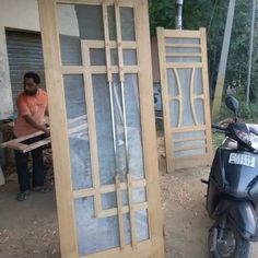 a motor bike parked next to a wooden door and another scooter in the background