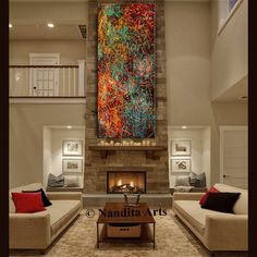 a living room filled with white couches and a fire place in front of a painting