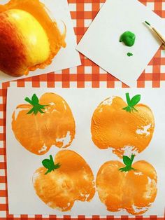 an apple and two oranges cut out on paper