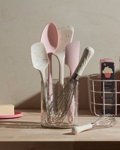 kitchen utensils are sitting in a glass container