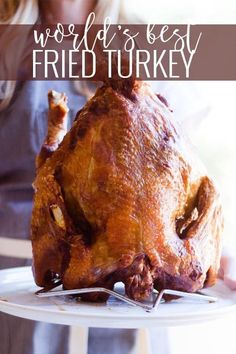 a woman holding a turkey on a plate with the words world's best fried turkey