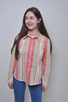 This vintage striped multicolor blouse is a vibrant and stylish piece from the 90s. Made from a blend of polyester, elastane, and cotton, it offers a comfortable fit with a touch of stretch. The blouse is a size M, with sleeve measurements of 46cm (18.11 inches) from armpit to end of sleeve, a width of 50cm (19.68 inches), and a length of 65cm (25.59 inches), all taken seam to seam while lying flat. Please note that this item is vintage and may have some defects, adding to its unique character. Summer Long Sleeve Blouse With Vertical Stripes, Casual Vertical Stripes Blouse For Fall, Long Sleeve Blouse With Vertical Stripes For Summer, Multicolor Long Sleeve Top With Vertical Stripes, 90s Striped Long Sleeve Tops, Spring Long Sleeve Tops With Vertical Stripes, Trendy Long Sleeve Shirt With Striped Collar, Spring Long Sleeve Blouse With Vertical Stripes, 90s Style Cotton Shirt For Spring