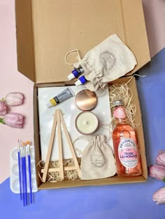 an open box containing candles, bottles and other items