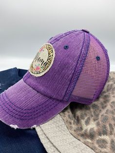 "Distressed trucker hat with featuring a trendy \"Mama\" patch that is securely sewn onto the hat. Hat is available in gray or purple. The hat has a velcro closure in the back allowing the fit to be adjusted. 6 panel hat. Front is made of cotton and back panels are mesh. Because each patch is handmade, there may be slight variations. Also, colors may appear different due to computer monitors. Remember to like our Facebook and Follow us on Instagram (@FabiLovesGracie) for new product updates, cou Casual Snapback Hat For Birthday, Purple Cap As A Gift, Purple Trucker Hat With Curved Brim, One Size, Purple Trucker Hat One Size, Adjustable Purple Trucker Hat With Curved Brim, Purple Trucker Hat With Curved Brim, Purple Adjustable Trucker Hat, Casual Purple Adjustable Trucker Hat, Purple Curved Brim Trucker Hat