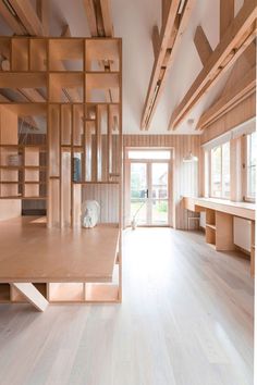 an empty room with wooden shelves and open doors