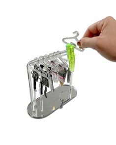 a person is holding a rack with keys and scissors in it on a white background