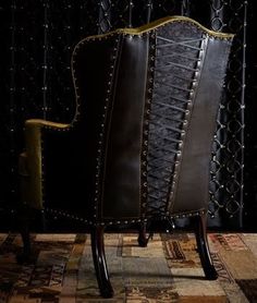 a brown leather chair sitting on top of a rug next to a black metal fence