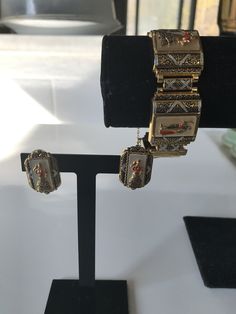 "Gorgeous gold gilt and mother of pearl in-laid Spanish toledo damascene five link bracelet featuring a lady dressed in a flamenco dress and a bull fighter in alternate panels. The bracelet has a push in slide closure and also comes with a safety chain. According to Wikipeda \"Damascening is the art of inlaying different metals into one another--typically, gold or silver into a darkly oxidized steel background--to produce intricate patterns similar to niello\". Approximate measurements: Bracelet Collectible Enamel Bracelet Jewelry, Traditional Enamel Jewelry With Matching Earrings, Wedding Enamel Bangle Jewelry, Antique Gold Bracelet Jewelry, Vintage White Jewelry For Ceremonial Occasions, Victorian Pierced Jewelry For Ceremonial Occasions, Victorian Enamel Jewelry For Wedding, Ornate Metal Jewelry Collectible, Elegant Pierced Enamel Jewelry