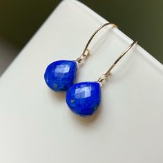 Microfaceted Lapis Lazuli briolettes sway from 14k yellow goldfilled earwires.   These gorgeous gemmy earrings are sure to punch up your wardrobe. Lapis measurements: 11mm Total length: 1 1/8 inch Please note that pictures of my jewelry are enlarged. The gemstone colors may vary on the device being used to view items. I do not alter the gemstone colors in my photos, but the backdrop can alter their look. My practice is always to add my jewelry last before heading out and to remove my jewelry fir Blue Teardrop Lapis Lazuli Jewelry, Blue Lapis Lazuli Teardrop Jewelry, Blue Briolette Teardrop Earrings For Gift, Blue Gemstone Teardrop Earrings, Adjustable Gemstone Briolette Earrings, Blue Teardrop Lapis Lazuli Earrings, Blue Lapis Lazuli Teardrop Earrings, Minimalist Blue Teardrop Jewelry, Lapis Lazuli Teardrop Earrings For Gifts