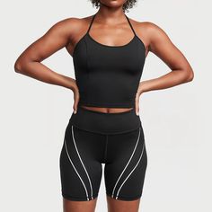 a woman in black sports bra top and bike shorts with her hands on her hips