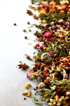 various types of flowers and spices on a white surface