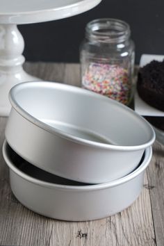 three cake pans sitting on top of a wooden table