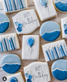 cookies decorated with blue and white icing are arranged in the shape of birthday balloons