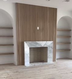 an empty room with a fireplace and shelves