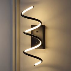 a wall mounted light that is on the side of a wall with a spiral design