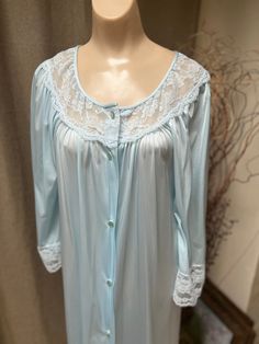 If you love anything in a soft aqua blue color you might fall in love with this pretty robe.   No indication it was ever worn.   Lightweight nylon is comfy and easy to wear.   Popular Gilead lingerie that you might have in your collection already. A  wide dyed to match lace section about the bust and on the 3/4 sleeves.  A bit of fullness in the sleeves. Buttons down the front. Single seam pocket. Nice fullness front and back. Wash in a mesh lingerie bag cool delicate cycle and hang to dry.  Onl Blue Nightgown For Spring, Fitted Light Blue Nightgown For Loungewear, Blue Spring Nightgown For Overnight, Light Blue Long Sleeve Nightgown For Spring, Light Blue Nightgown For Home, Blue Spring Robe For Home, Blue Home Robe For Spring, Long Sleeve Blue Nightgown For Home, Light Blue Lace Trim Nightgown For Home