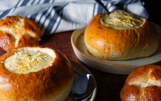 some bread bowls with soup in them on a table