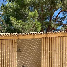 an outdoor shower with bamboo walls and trees in the background