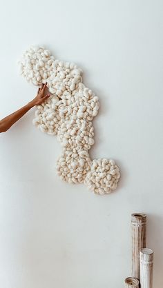 a person is painting the wall with white yarn