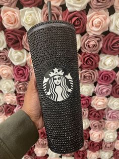 the starbucks cup is in front of roses