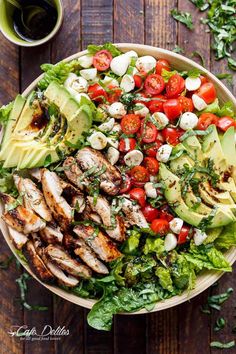 a salad with chicken, avocado, tomatoes and lettuce