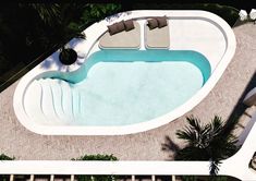 an aerial view of a swimming pool with lounge chairs