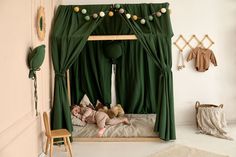 two babies sleeping in a green canopy bed with drapes on the top and bottom