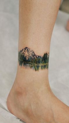 a person with a mountain tattoo on their foot