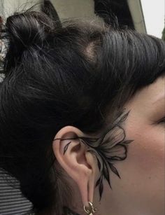 a woman with tattoos on her face and ear