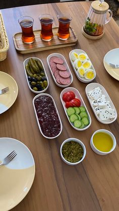 the table is set with many different foods and drinks on it, including pickles