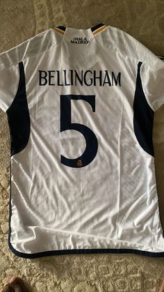 a white shirt with the number five on it