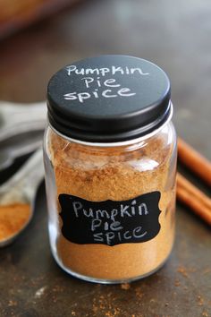 a jar filled with pumpkin pie spice next to cinnamon sticks