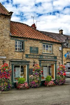 an old building with flower boxes on the front and flowers growing out of it's windows